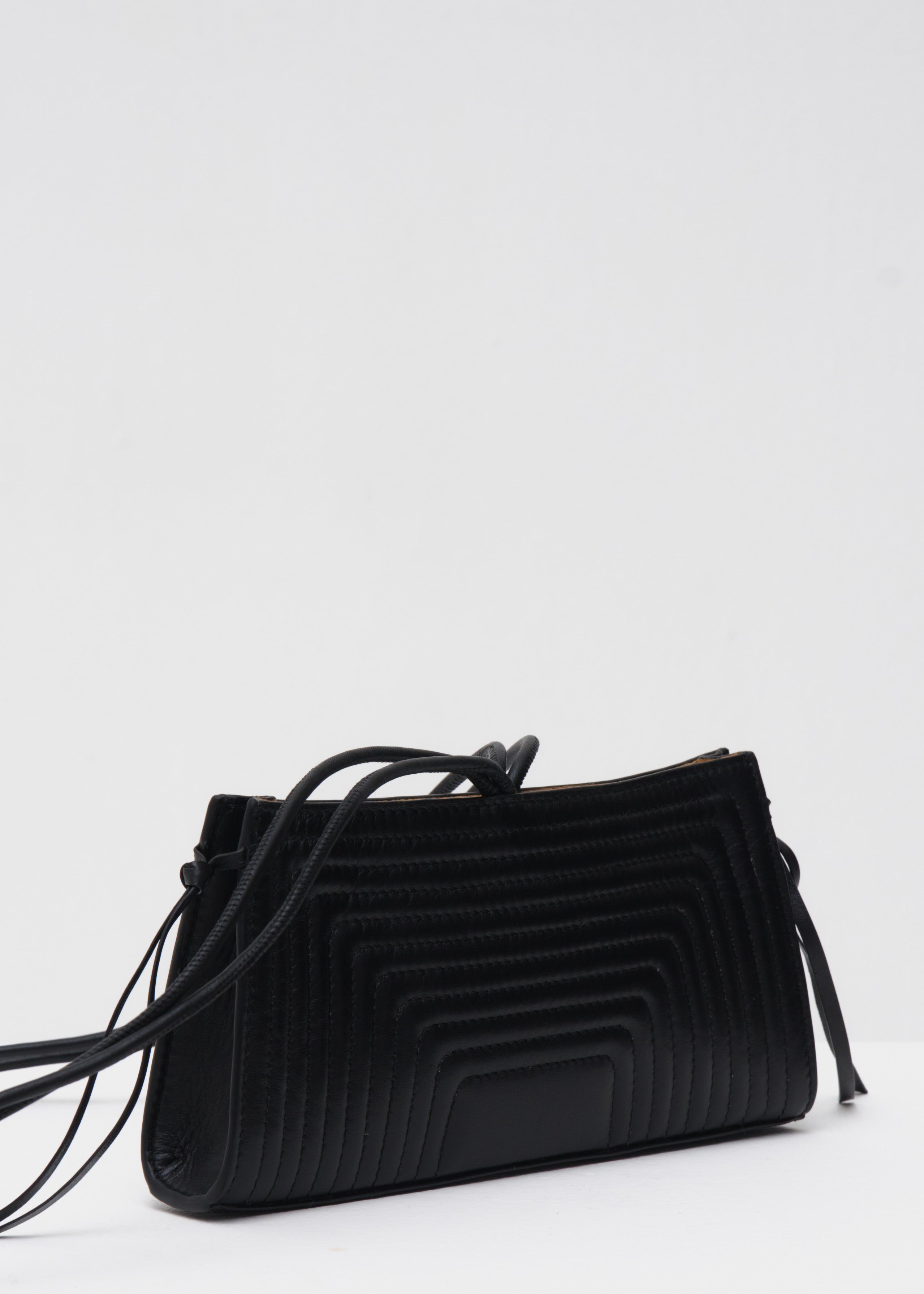 Black crossbody bag with a textured pattern on a white background