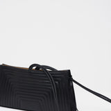 Black handbag with a strap on a white background