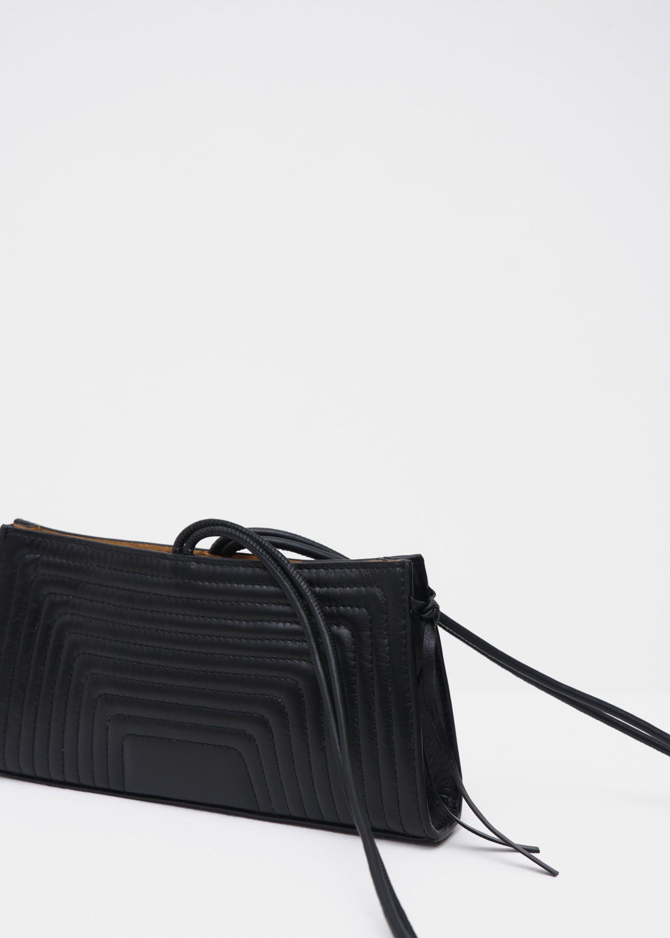 Black handbag with a strap on a white background