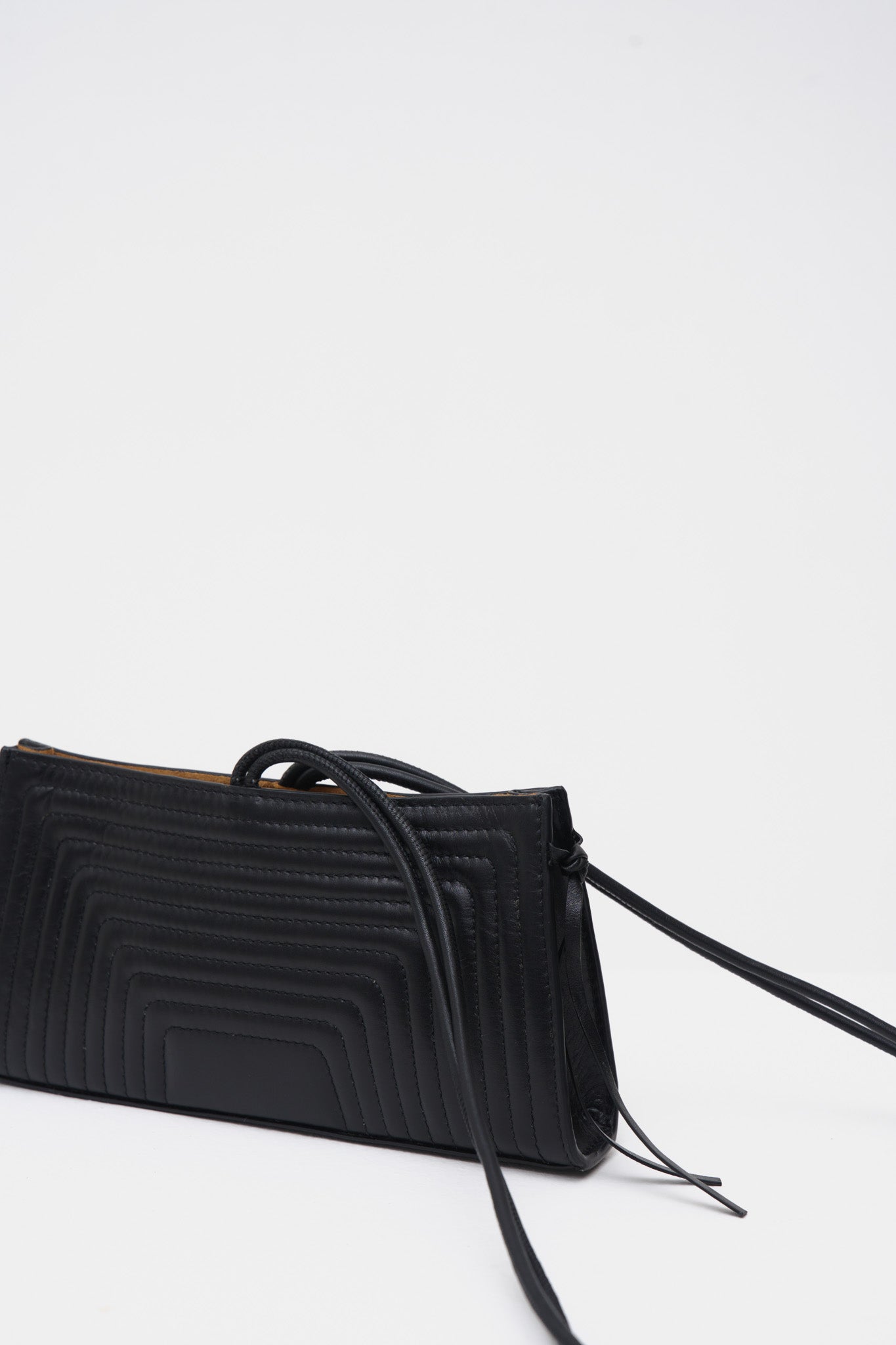 Black handbag with a strap on a white background