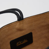 Interior lining of a black crossbody bag against a white background