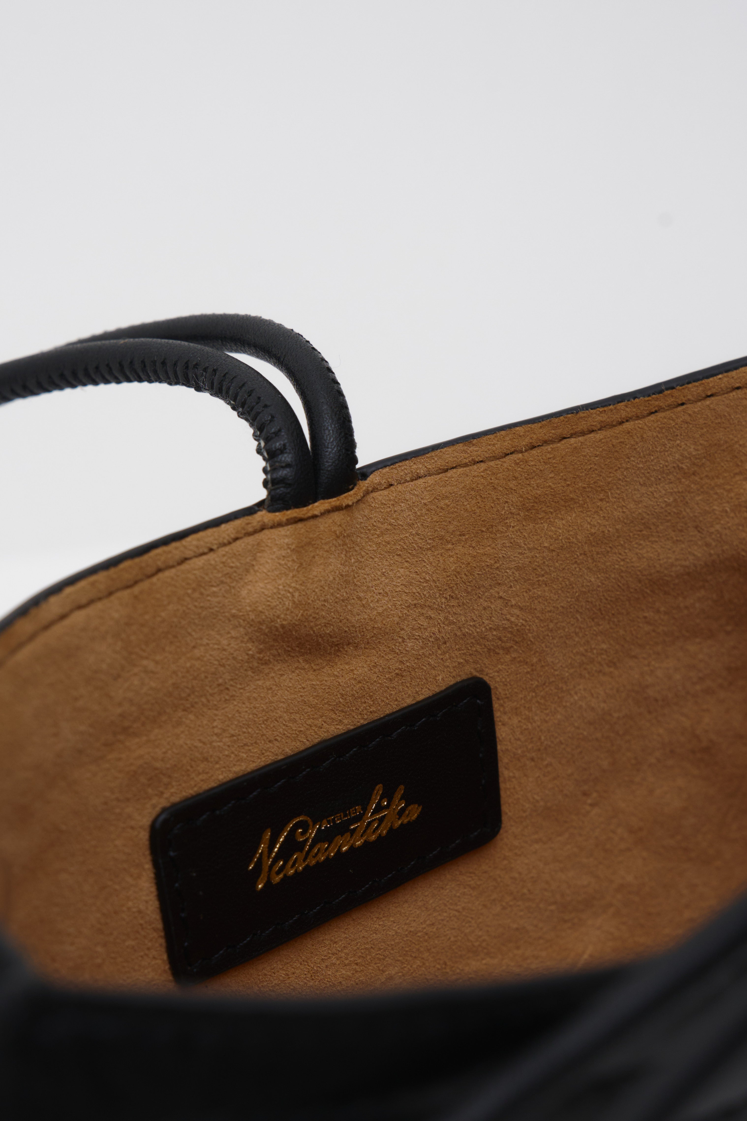 Interior lining of a black crossbody bag against a white background