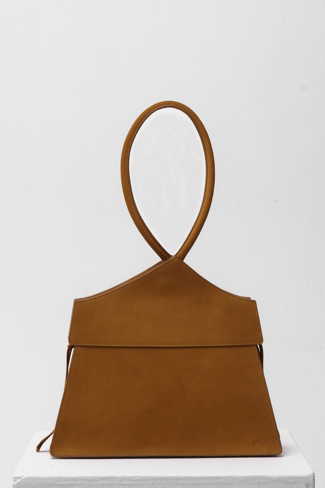 Brown suede handbag on a white background