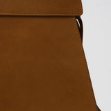 Close-up of a brown suede bag with a visible brand logo on a white background
