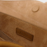Close-up of a brown suede bag with a visible brand label.