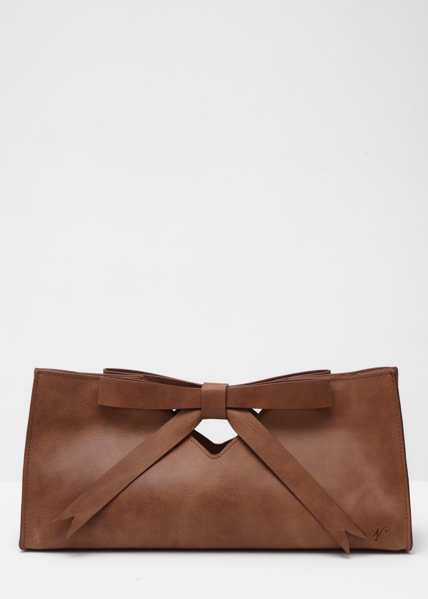 Brown leather clutch bag with a bow on a white background