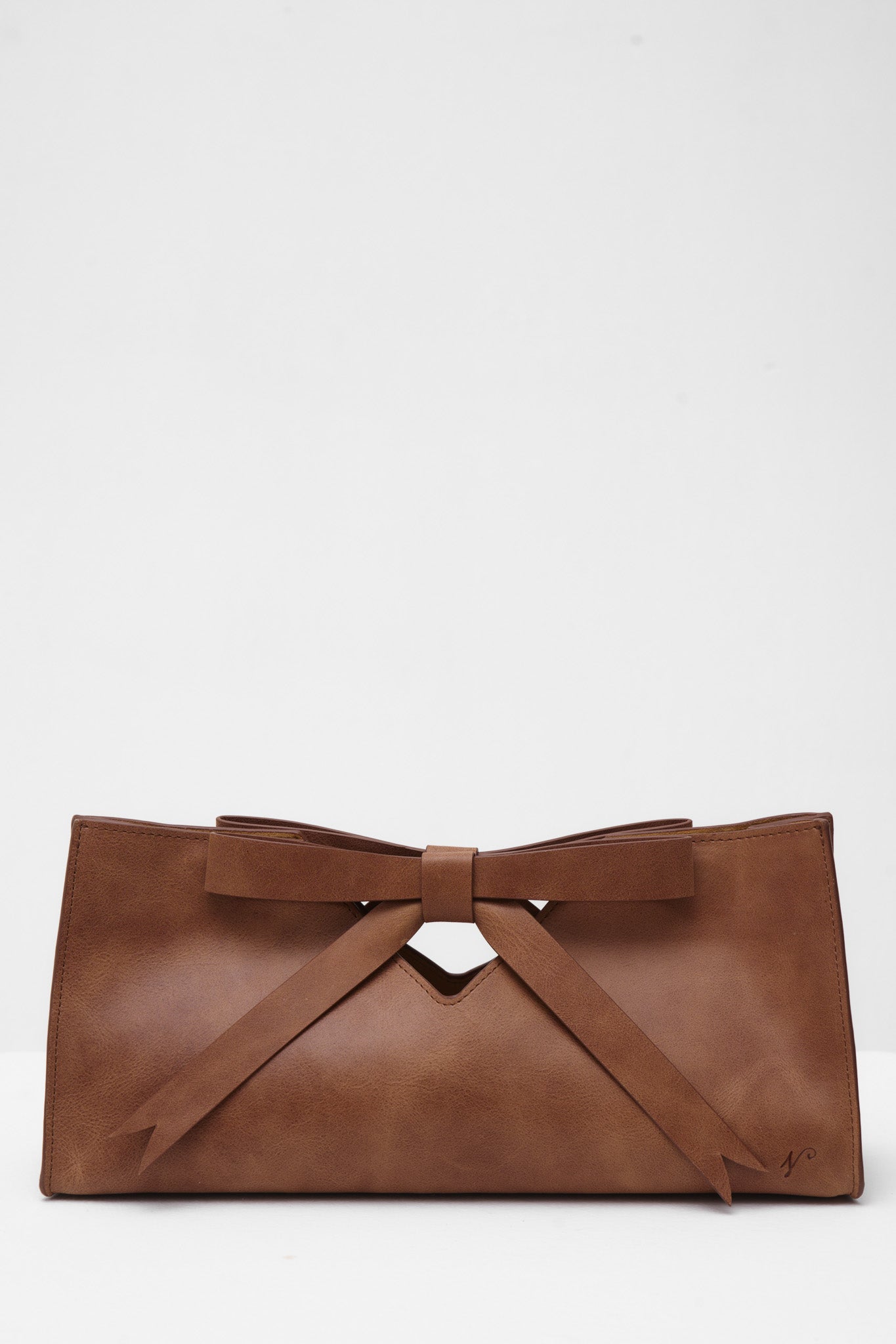 Brown leather clutch bag with a bow on a white background