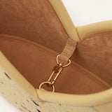 Close up of a hair-on leather handbag against a white background