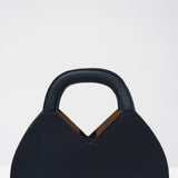 Navy blue handbag with a structured handle on a white background