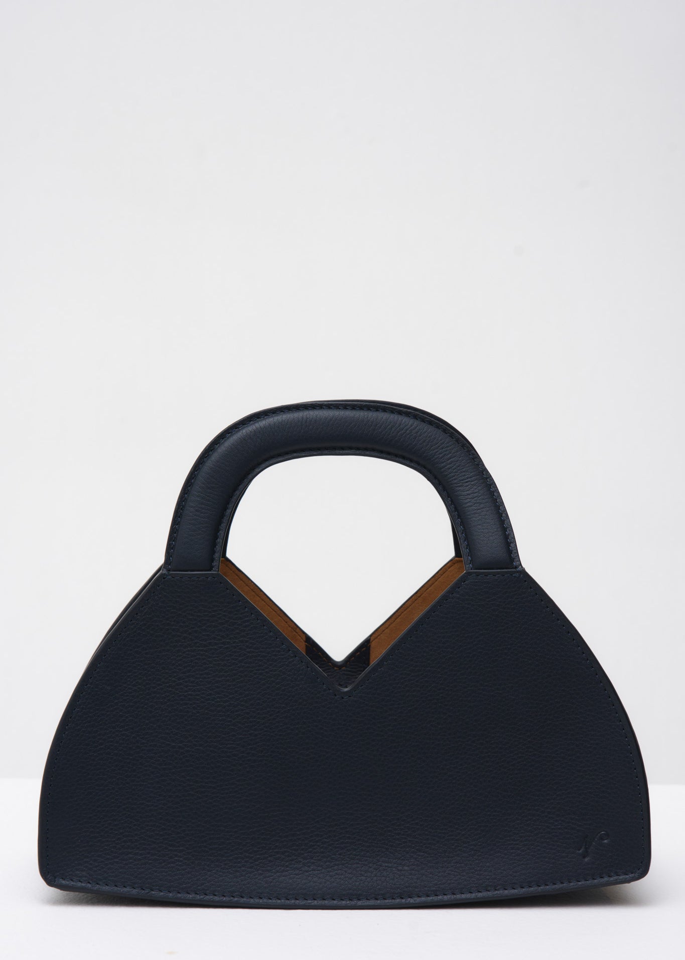 Navy blue handbag with a structured handle on a white background