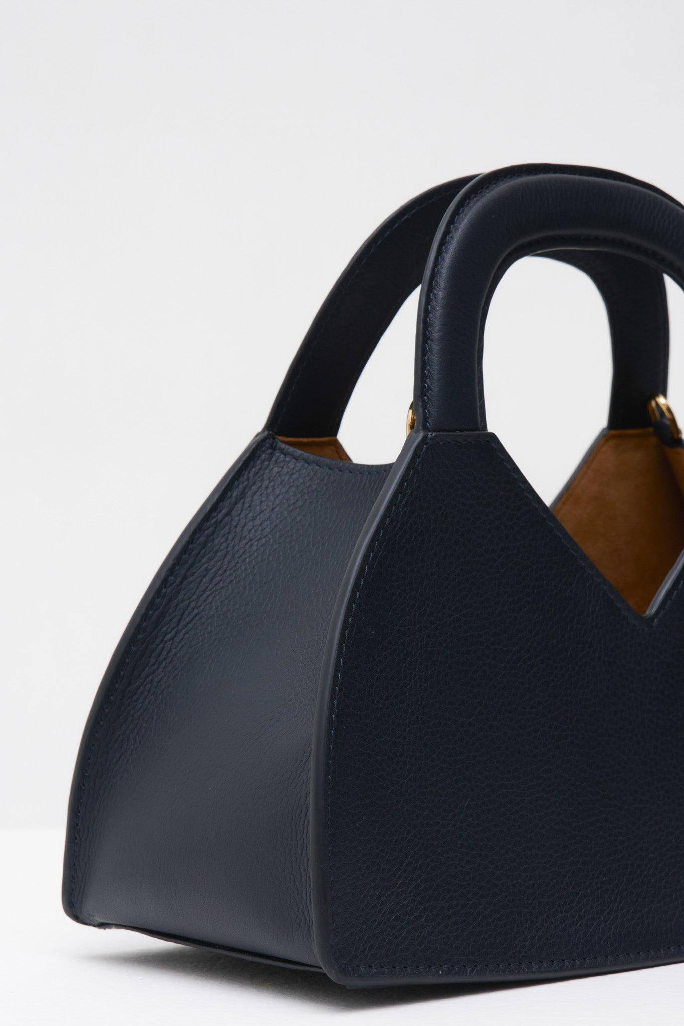 Navy blue handbag with a brown interior on a white background