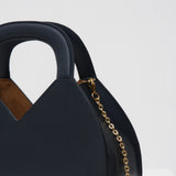 Navy blue handbag with gold chain on a white background