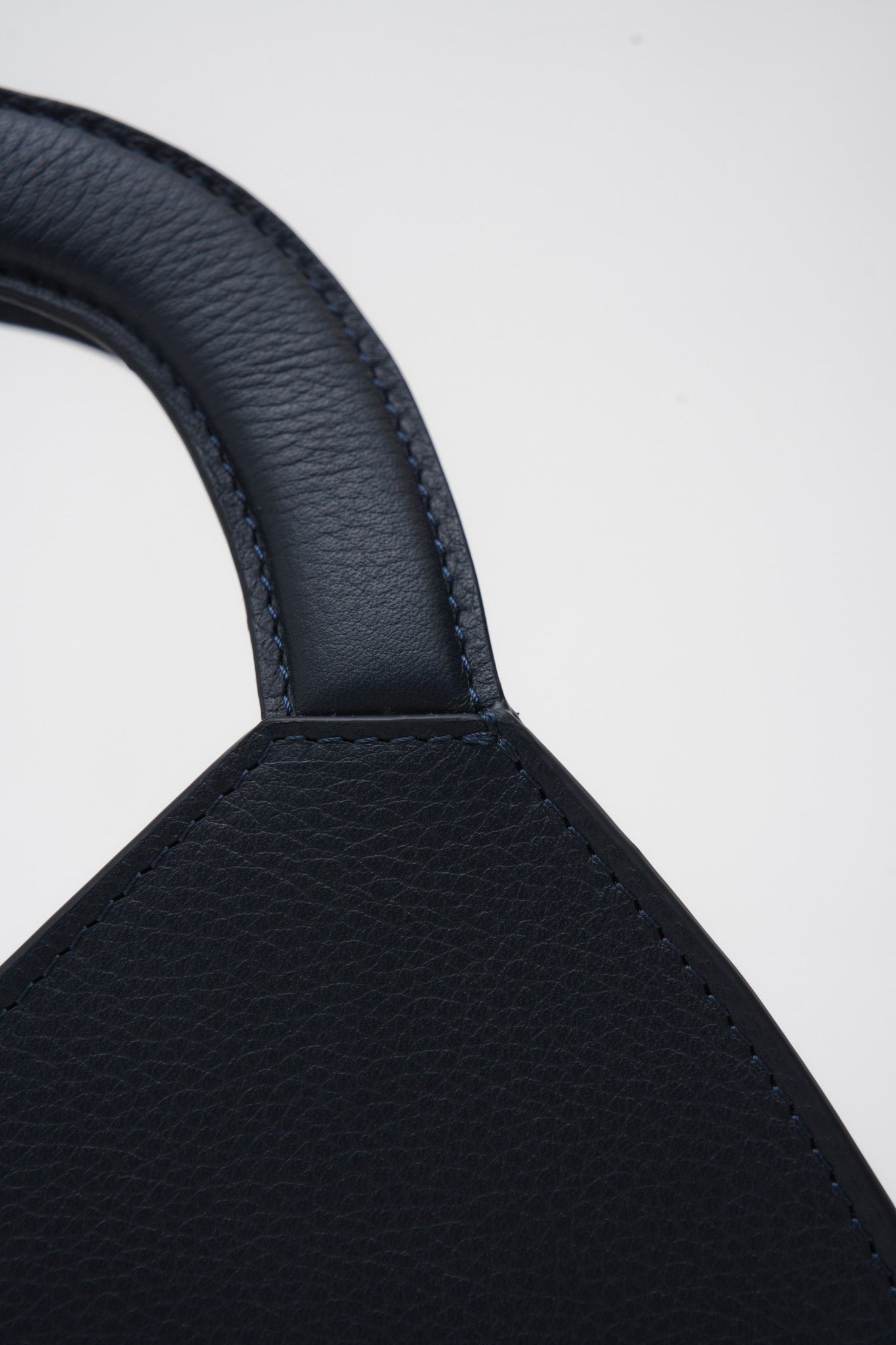 Close-up of a navy blue leather product on a white background
