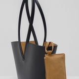 Black leather shoulder bag with a matching brown pouch on a white background