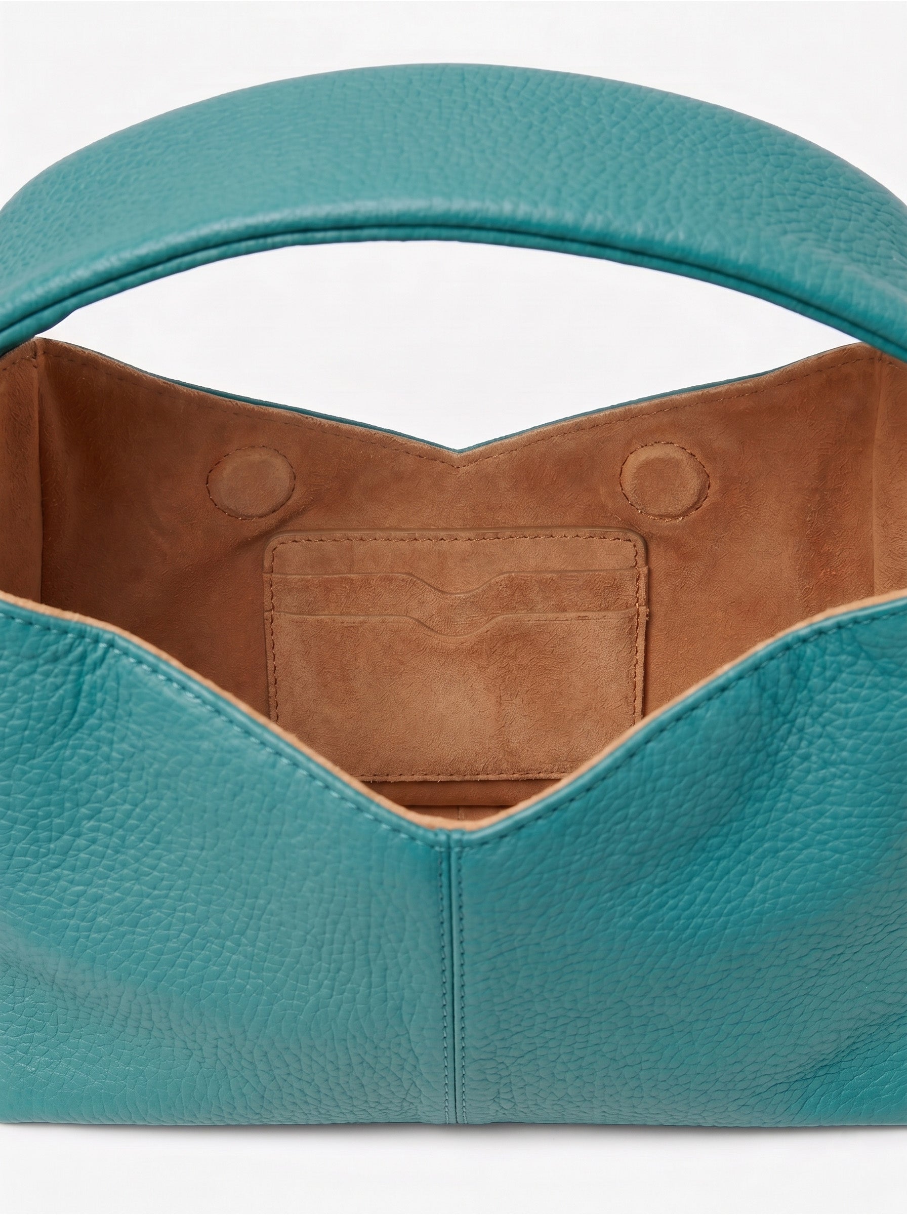 Close-up of a teal handbag with brown interior on a white background