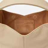 Close-up of a beige leather handbag with a white background