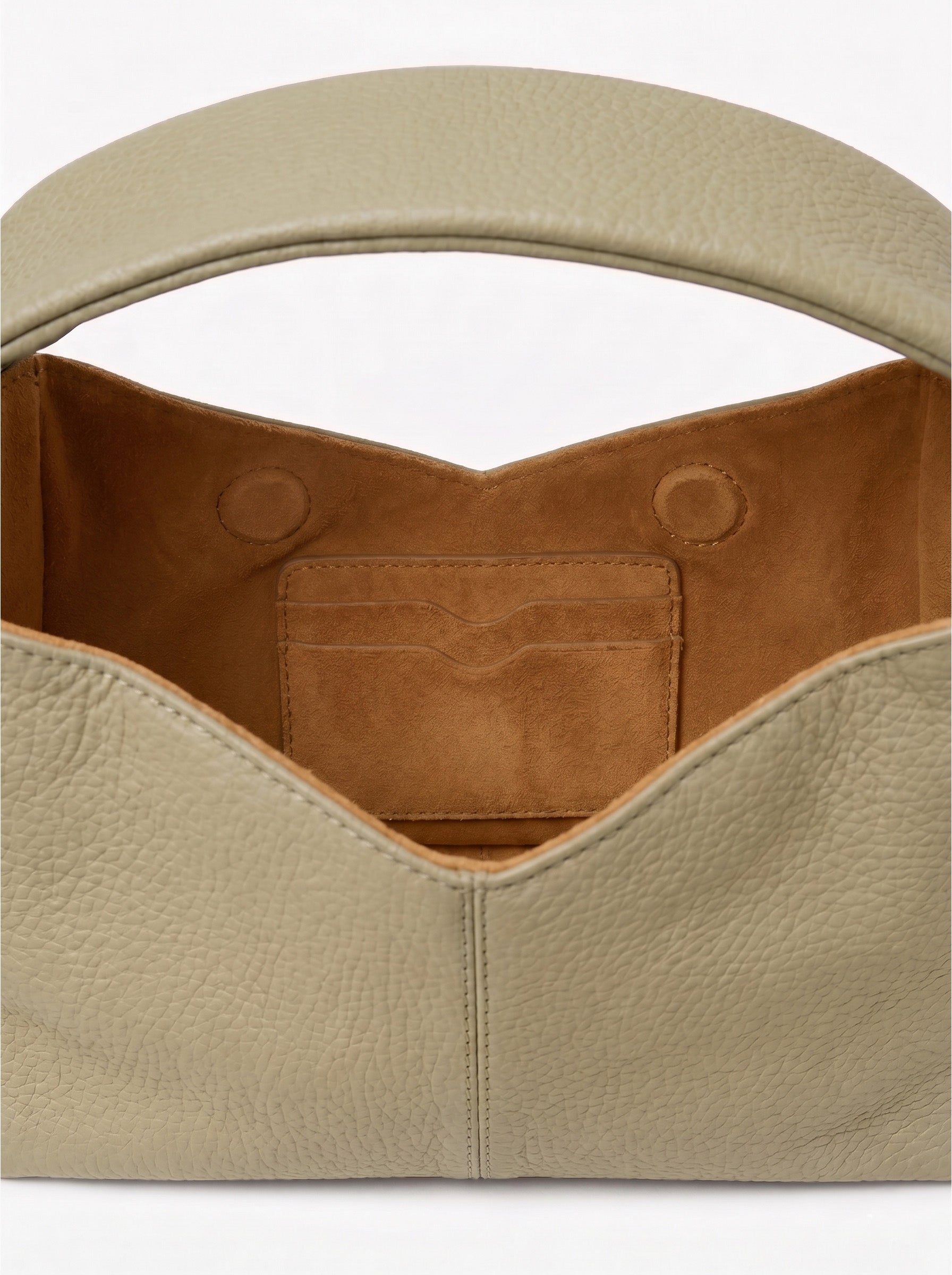 Close-up of a pastel green leather handbag with a brown interior pocket on a white background